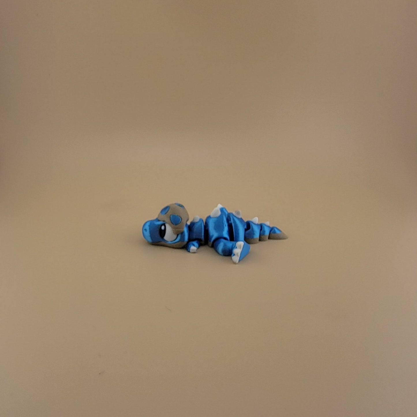 Baby T-Rex laying down flexi 3d printed articulated dinosaur blue