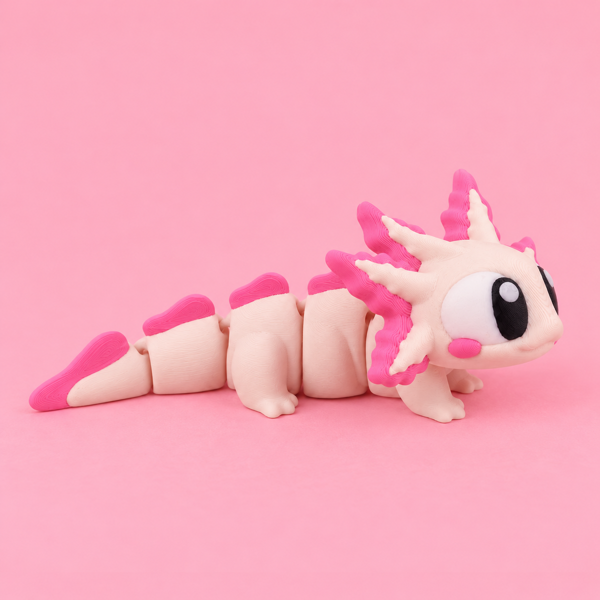Side view of a pale pink articulated axolotl showing its jointed body, bright pink gills, and segmented tail.
