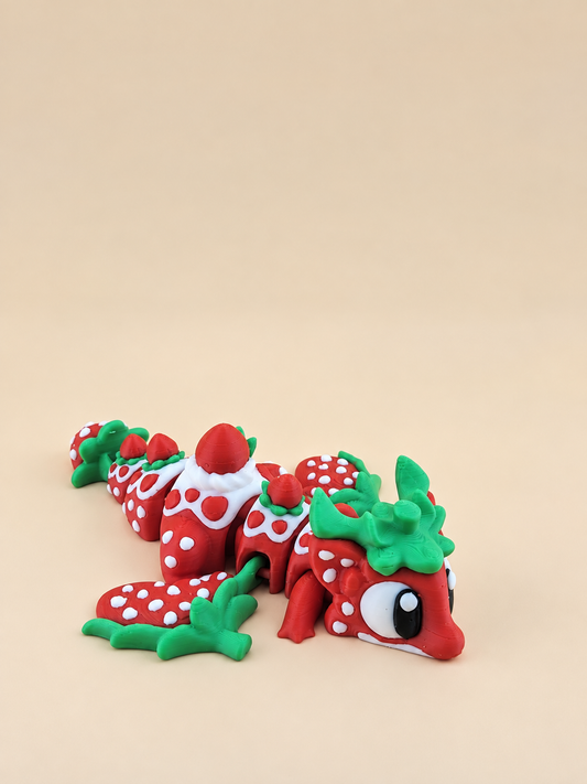 Articulated Strawberry Dragon with red and white body and green leaf details, viewed from the front